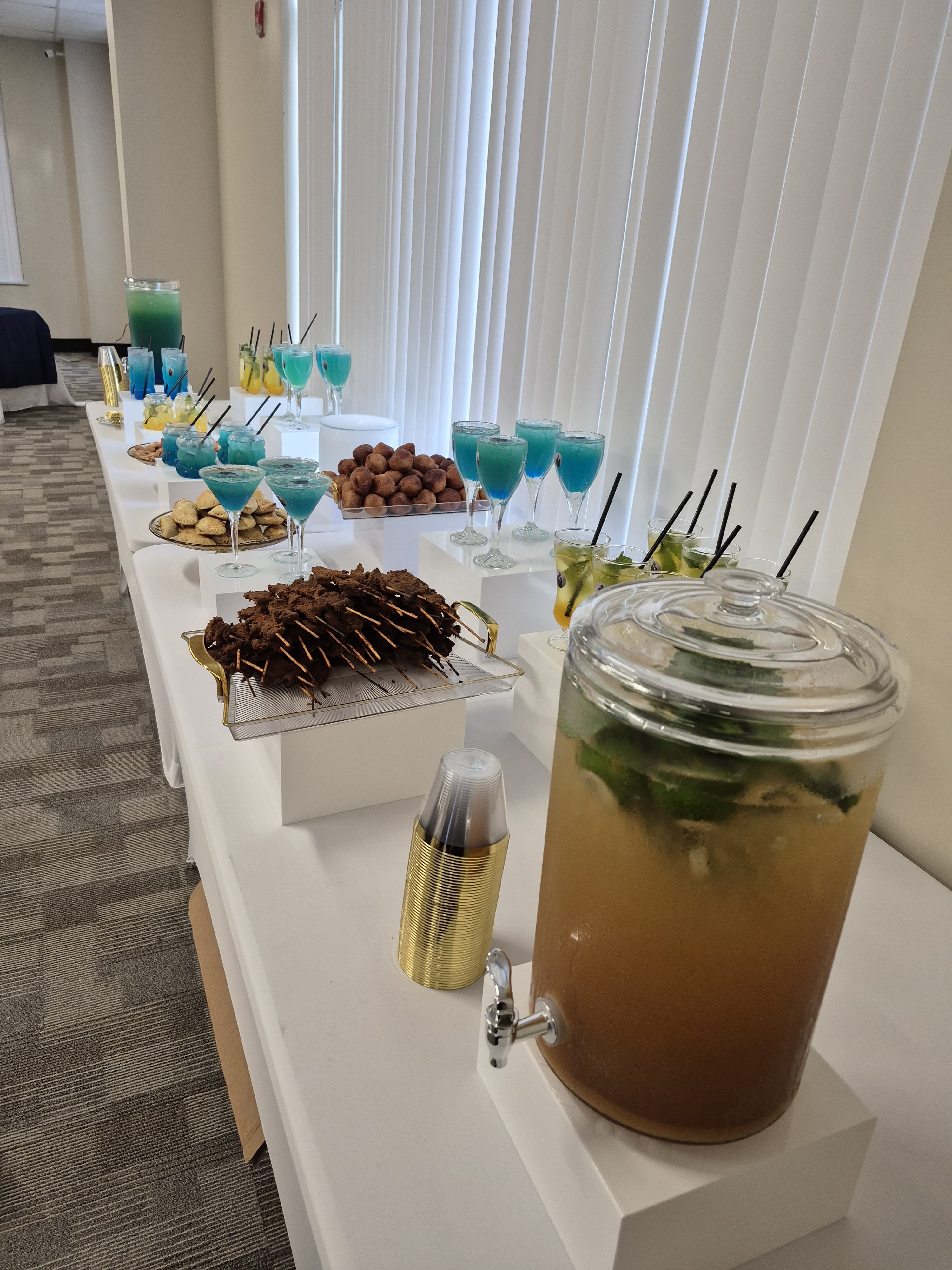 Corporate drinks station with blue cocktails and appetizers